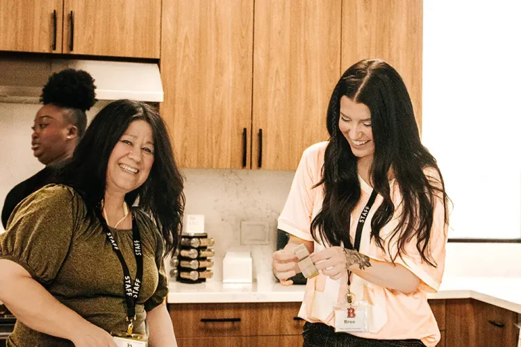 Staff members laugh together while participating in an activity at the day program, showing teamwork and a positive, caring environment.